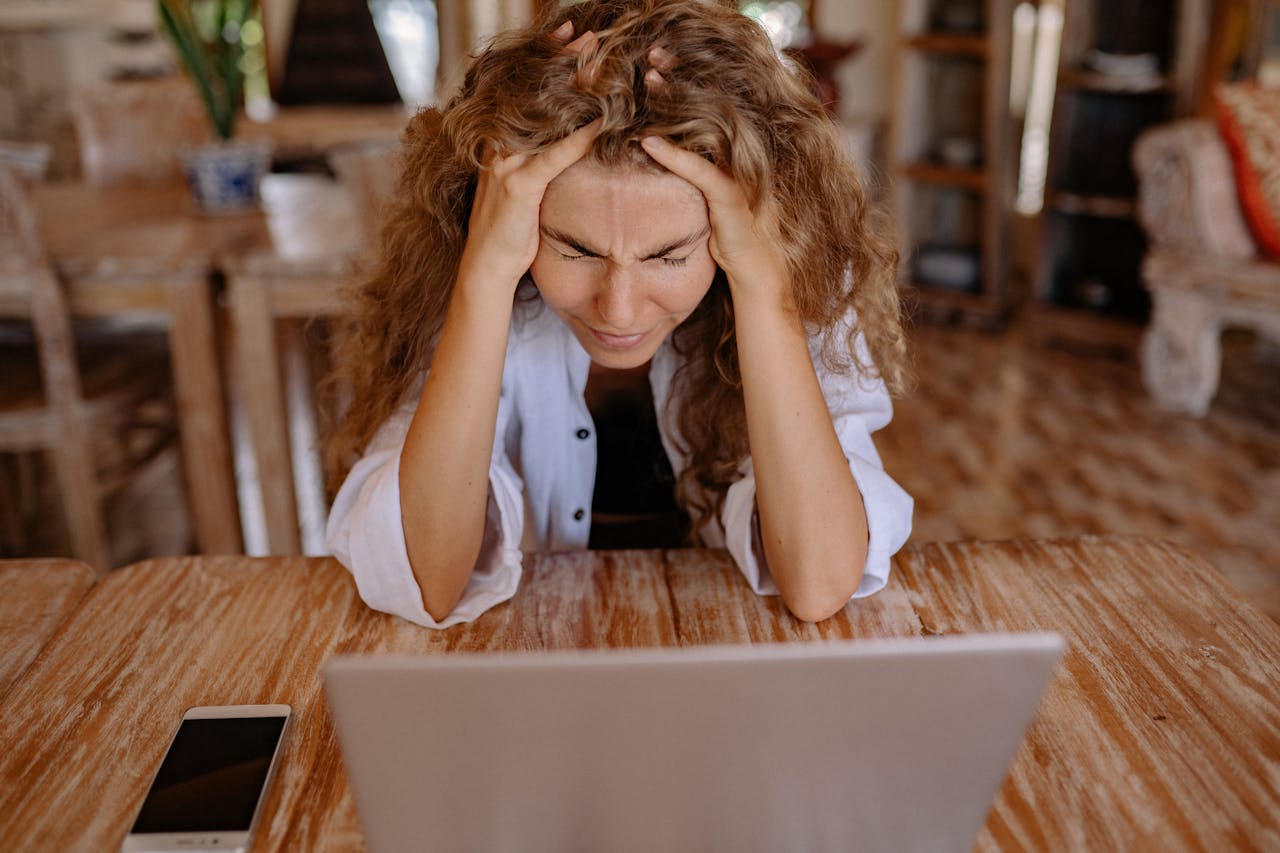 Stressed out woman holding her head in both hands
