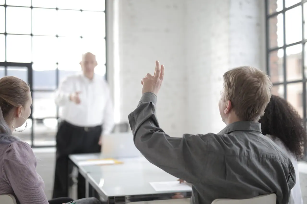 A man raising his hand to ask a question